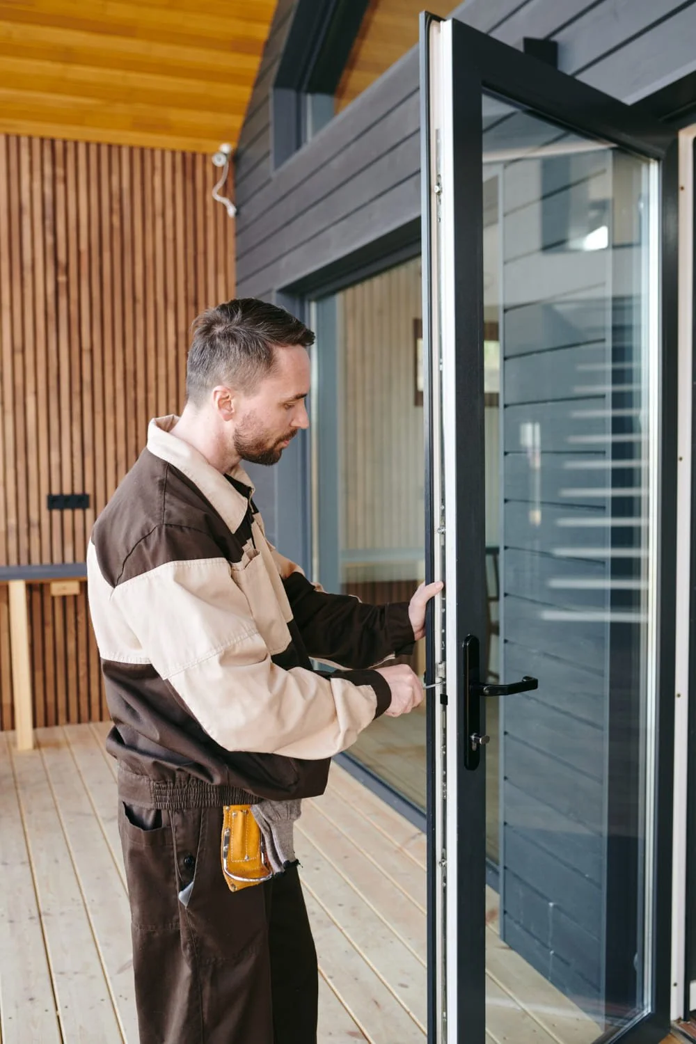 jeune-reparateur-debout-devant-porte-vitree-tout-reparant-serrure (1) Chez François, menuisier, vitrier et serrurier Toulouse