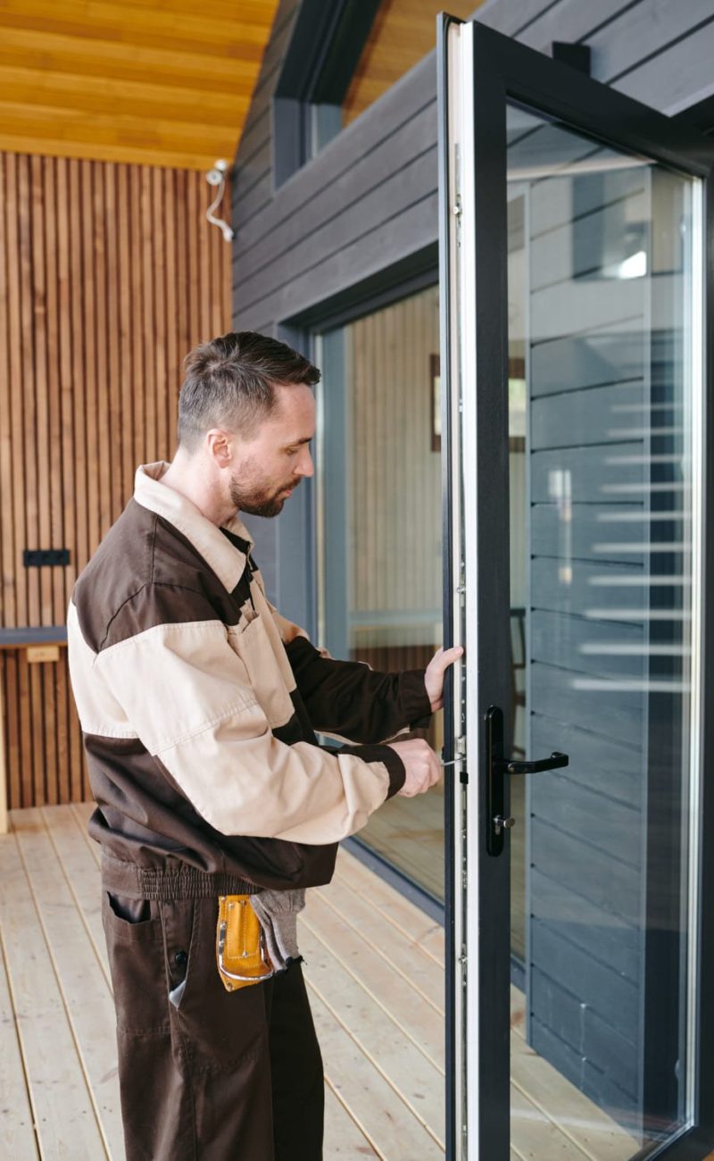 jeune-reparateur-debout-devant-porte-vitree-tout-reparant-serrure (1) Chez François, menuisier, vitrier et serrurier Toulouse
